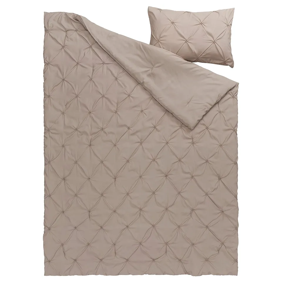 A BÄGARKLOCKA comforter set in beige, with a textured pintuck design, made of recycled polyester, suitable for a cosy bed.