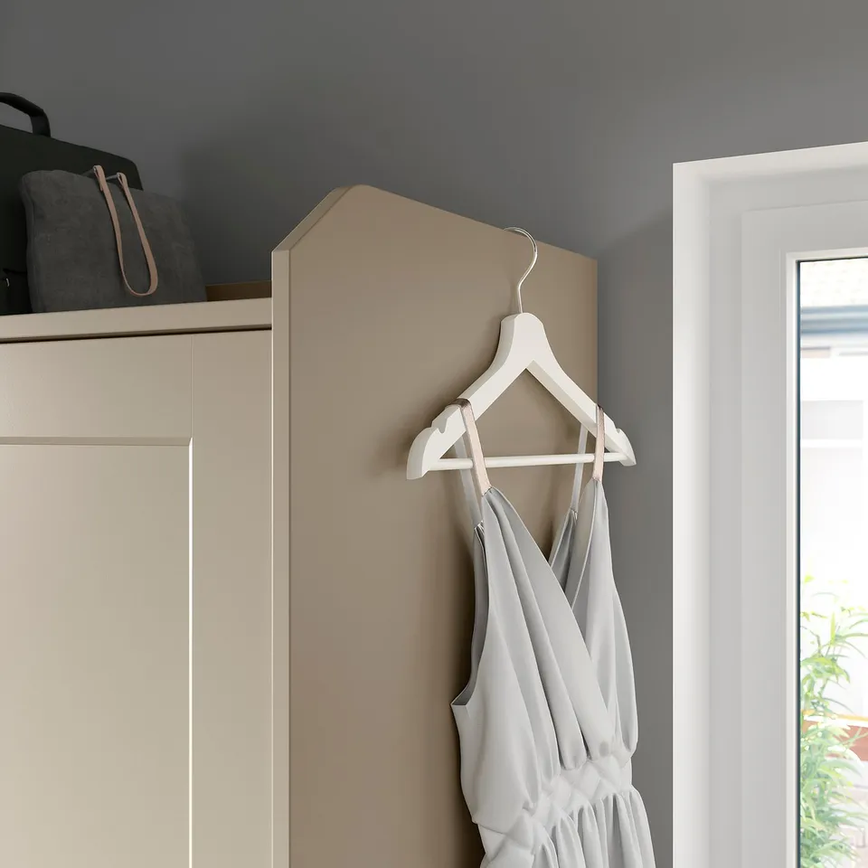 HAUGA wardrobe: sliding doors, hangers & shelves. Dress on hanger, safety wall fitting.