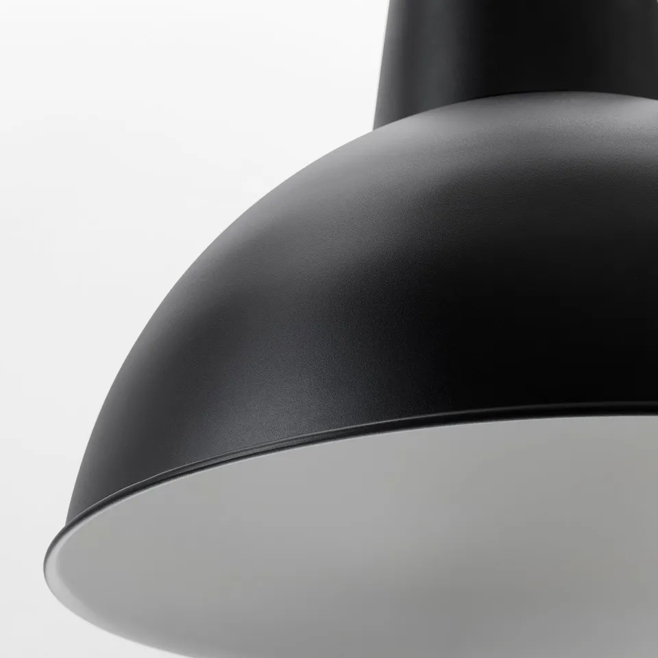 Close-up of a sleek, modern black pendant lamp, showcasing its smooth, high-quality painted metal shade and robust design.