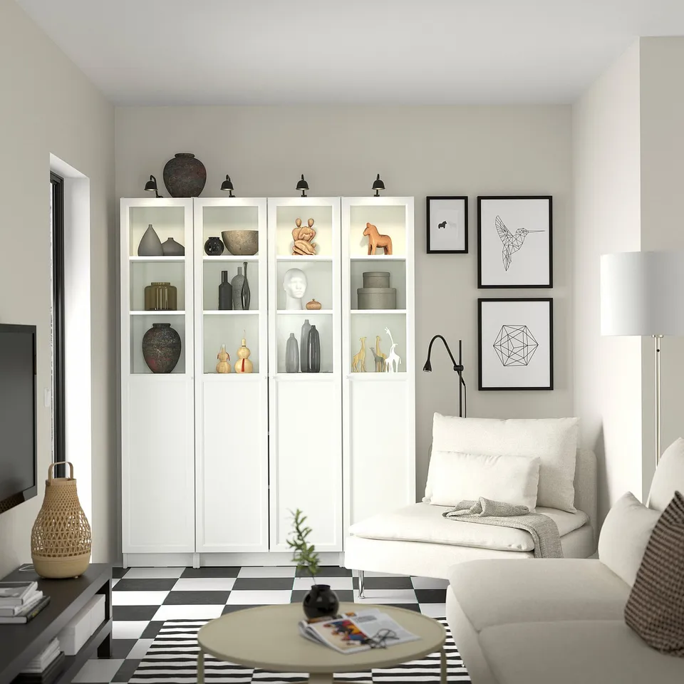 Modern living room with BILLY bookcase, sofa, chequered rug, lamp, tv, and artwork.