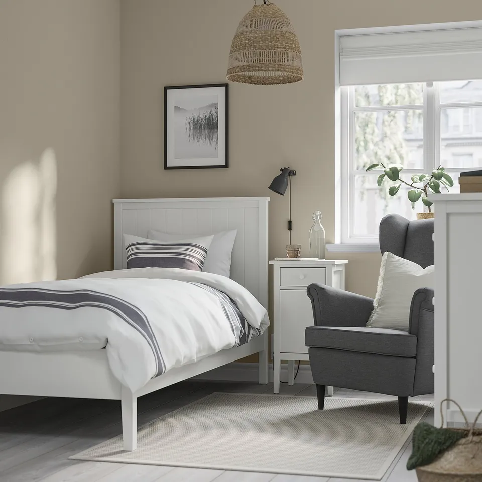 Cosy bedroom with white GULLABERG bed, grey bedding, armchair, bedside table, and large window.
