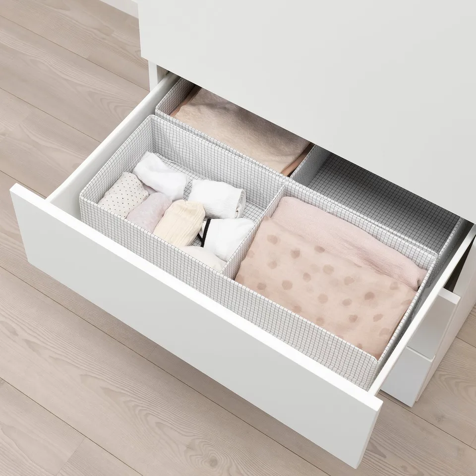 Open platsa drawer revealing folded clothes and pillows, showing storage capacity and organisation.