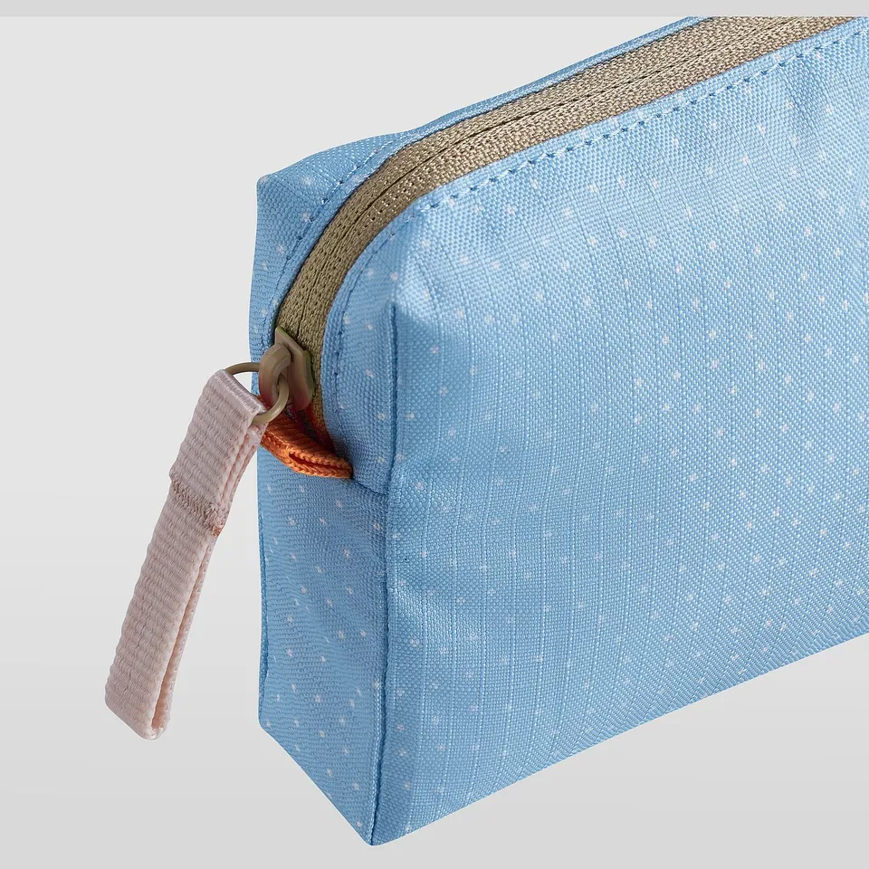 Small zippered bag, light blue with tiny white dots, sturdy handle, top zip closure.