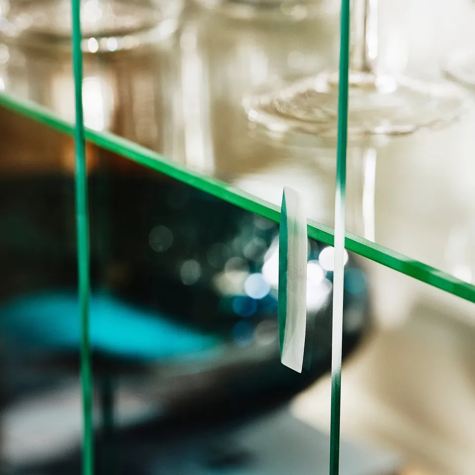 Modern glass display cabinet with green frame, showcasing elegant design and sturdy construction.