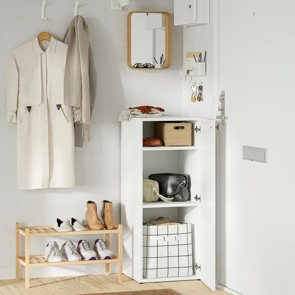Organised entryway with hanging coat, shoes on rack, bags, and items in cabinet. Adjustable feet and wall-mounted.