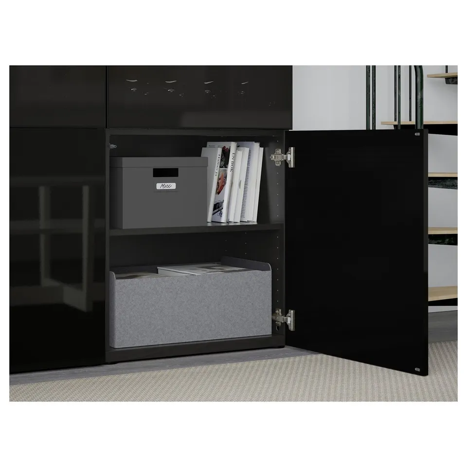 An open black cabinet with two shelves showing grey storage boxes and magazines on top, demonstrating organised storage.