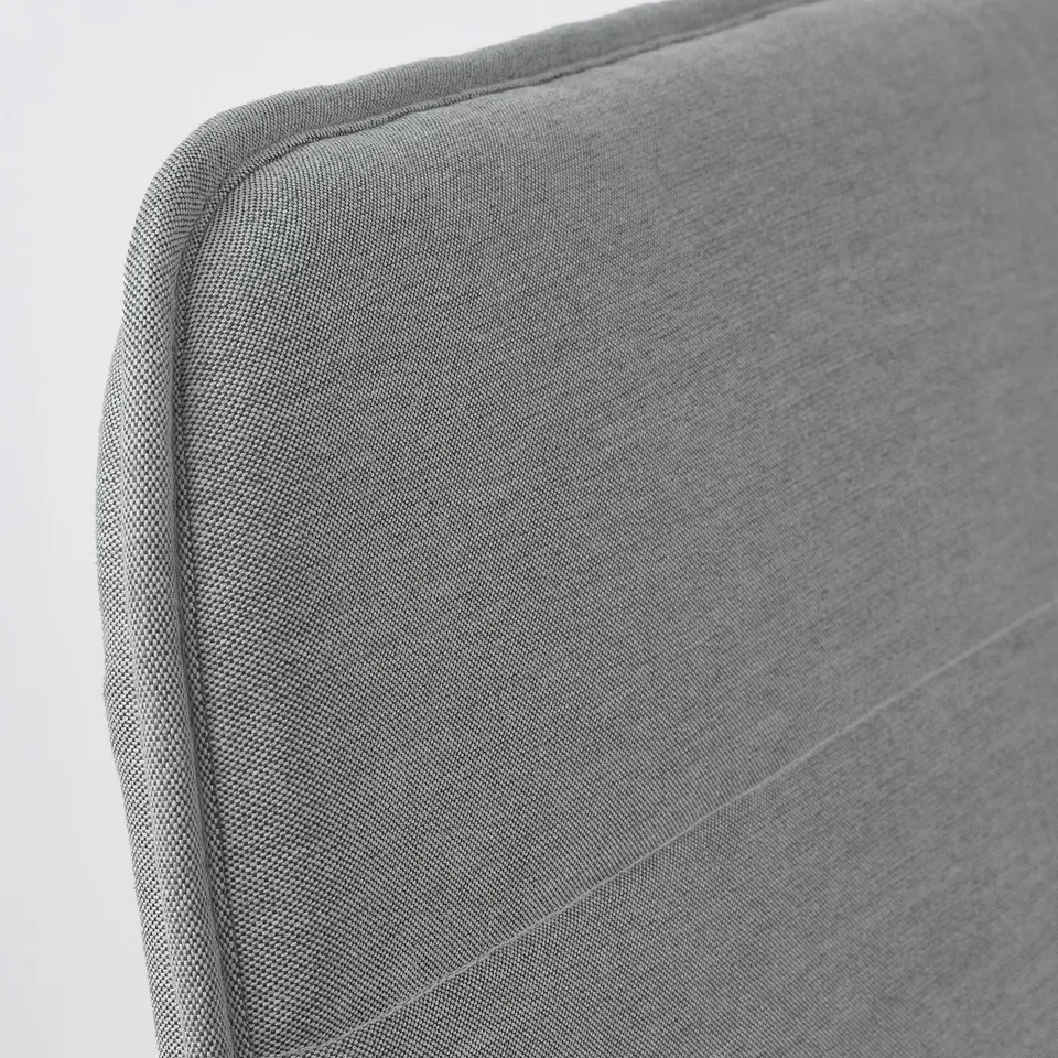 A close-up of a grey upholstered chair, showcasing its well-crafted, smooth fabric and sturdy stitching.