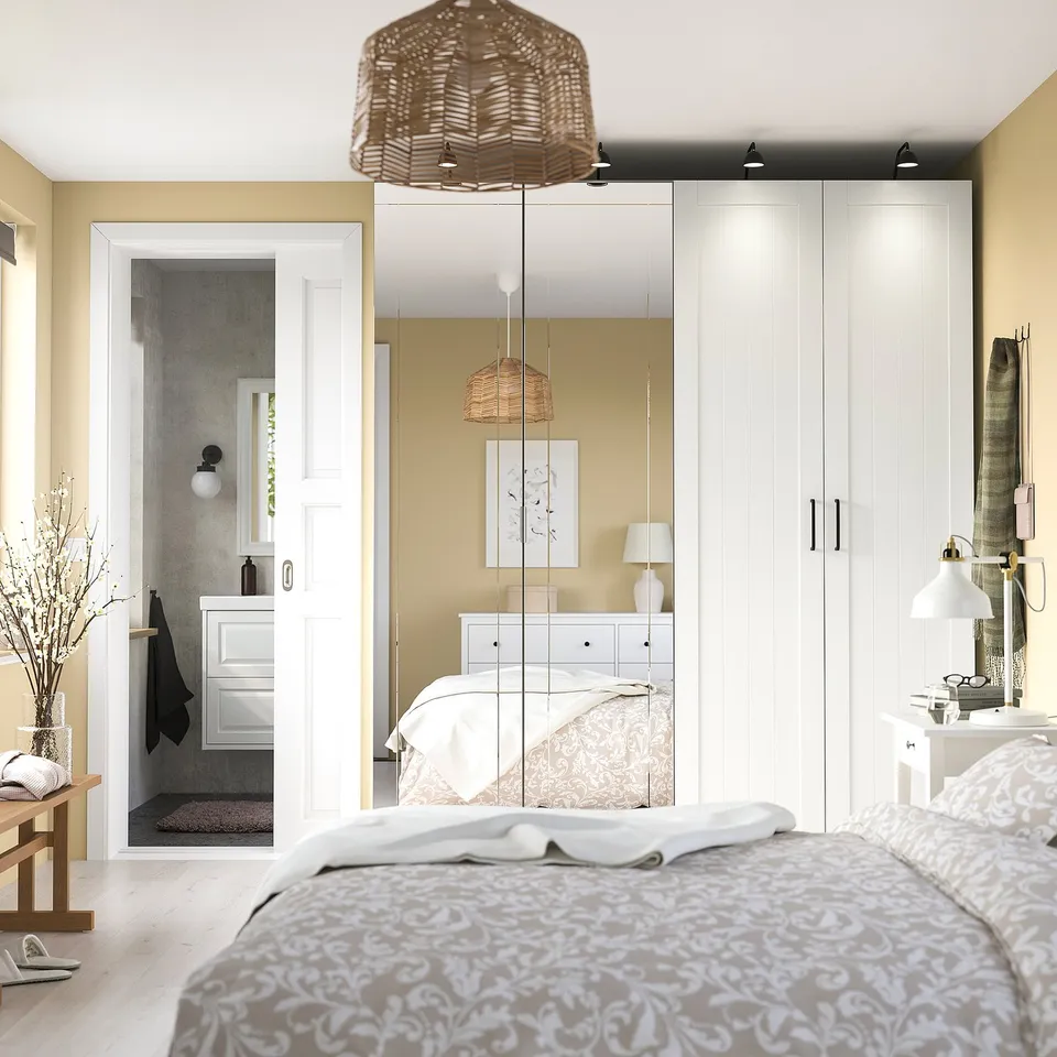 Bedroom with large KAMMARTORP wardrobe, floral bed, and open bathroom.
