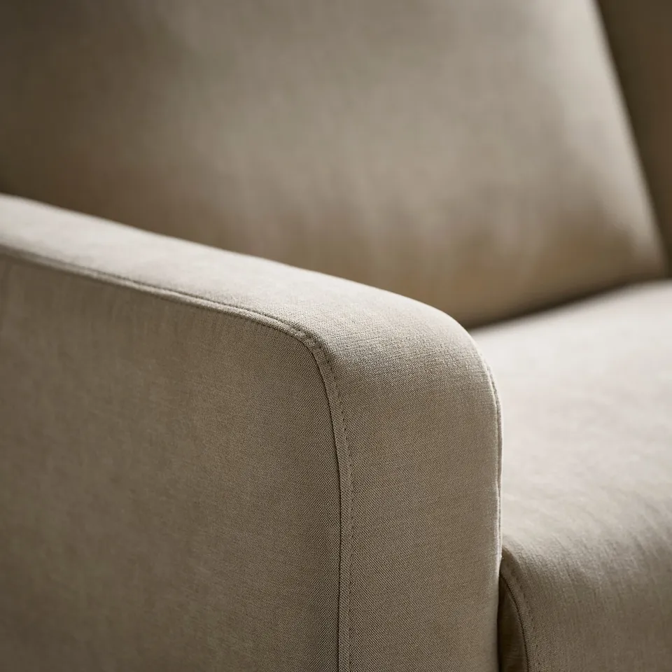 Close-up of a well-crafted, beige sofa arm, showcasing its soft, textured fabric and sturdy construction.