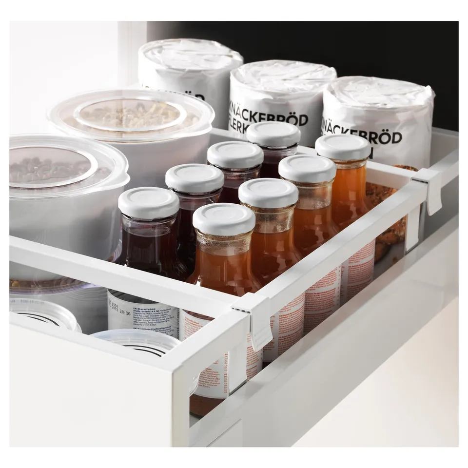 Fridge drawer with honey jars, large containers, and small white lids, organised for easy access.