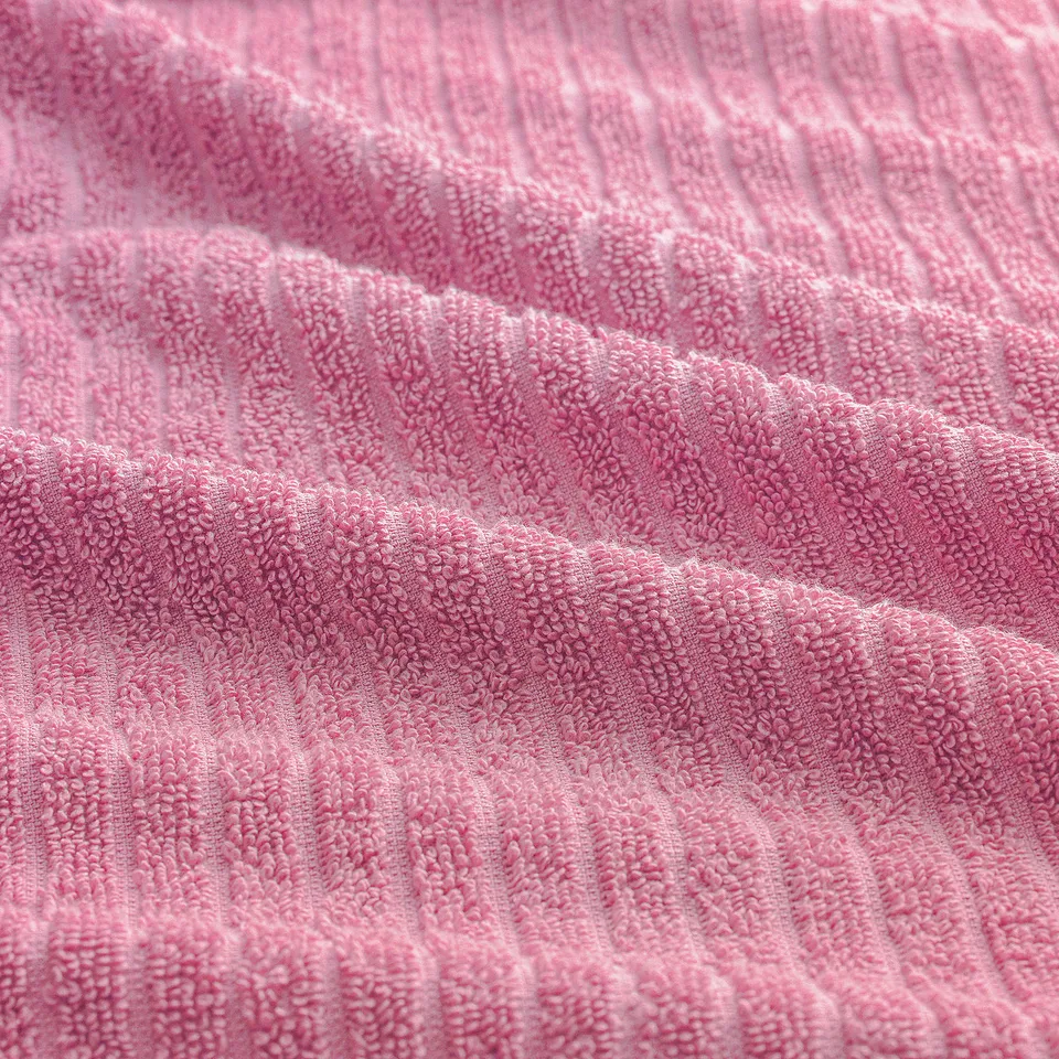 Close-up of soft pink bath towel, textured terry cloth, inviting touch.
