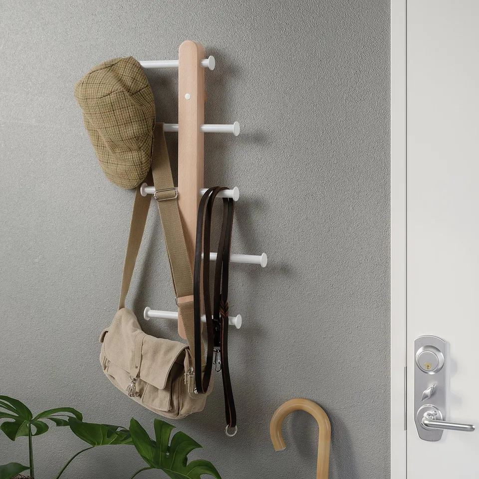 Wall-mounted coat rack with hat, bag, and umbrella hanging.