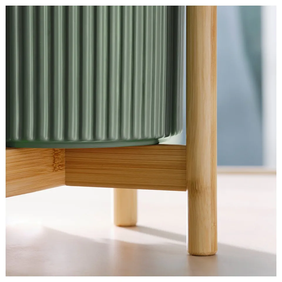 Green corrugated planter with bamboo stand, showing sturdy construction and natural finish.