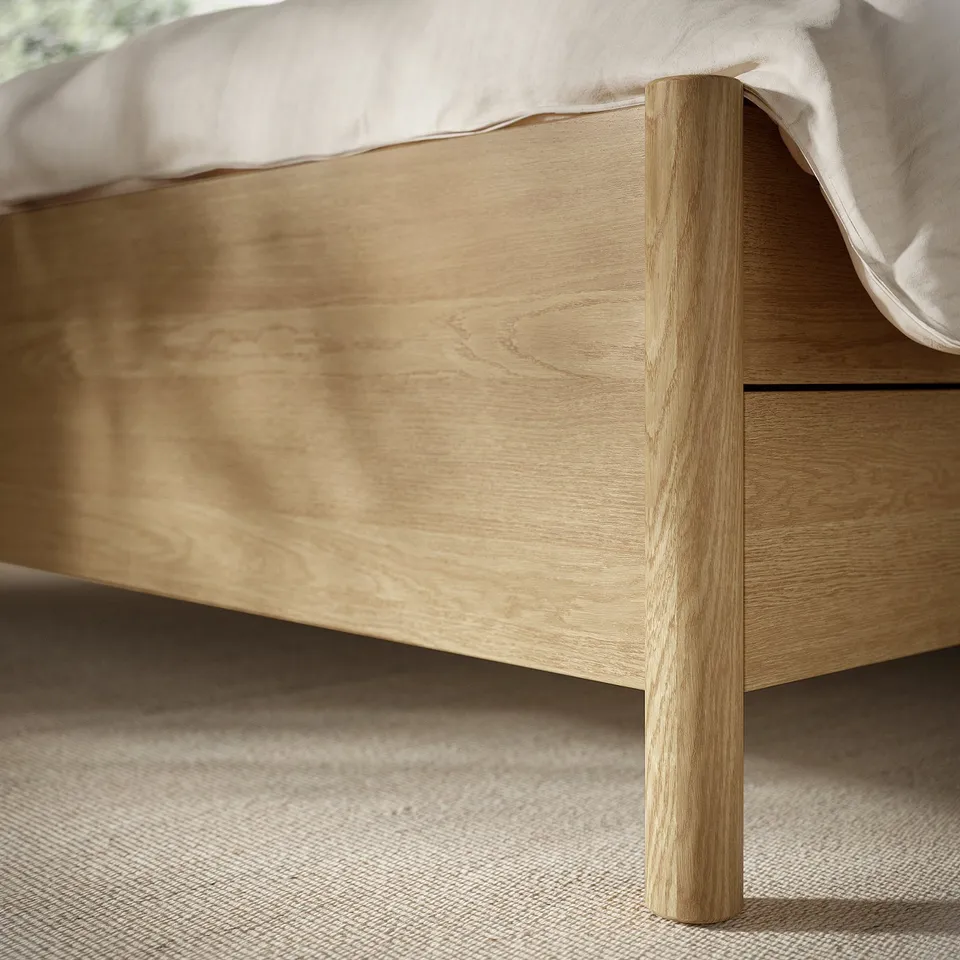 Close-up of a sturdy wooden bed leg with a smooth finish, showcasing the quality and natural grain of the TONSTAD bed frame.