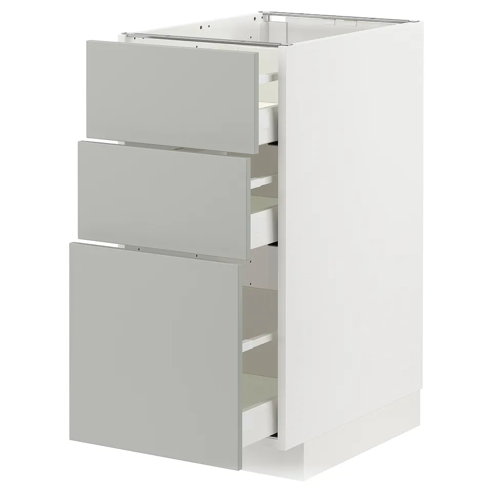 A white METOD kitchen cabinet with light grey drawers, featuring a modern and clean design.