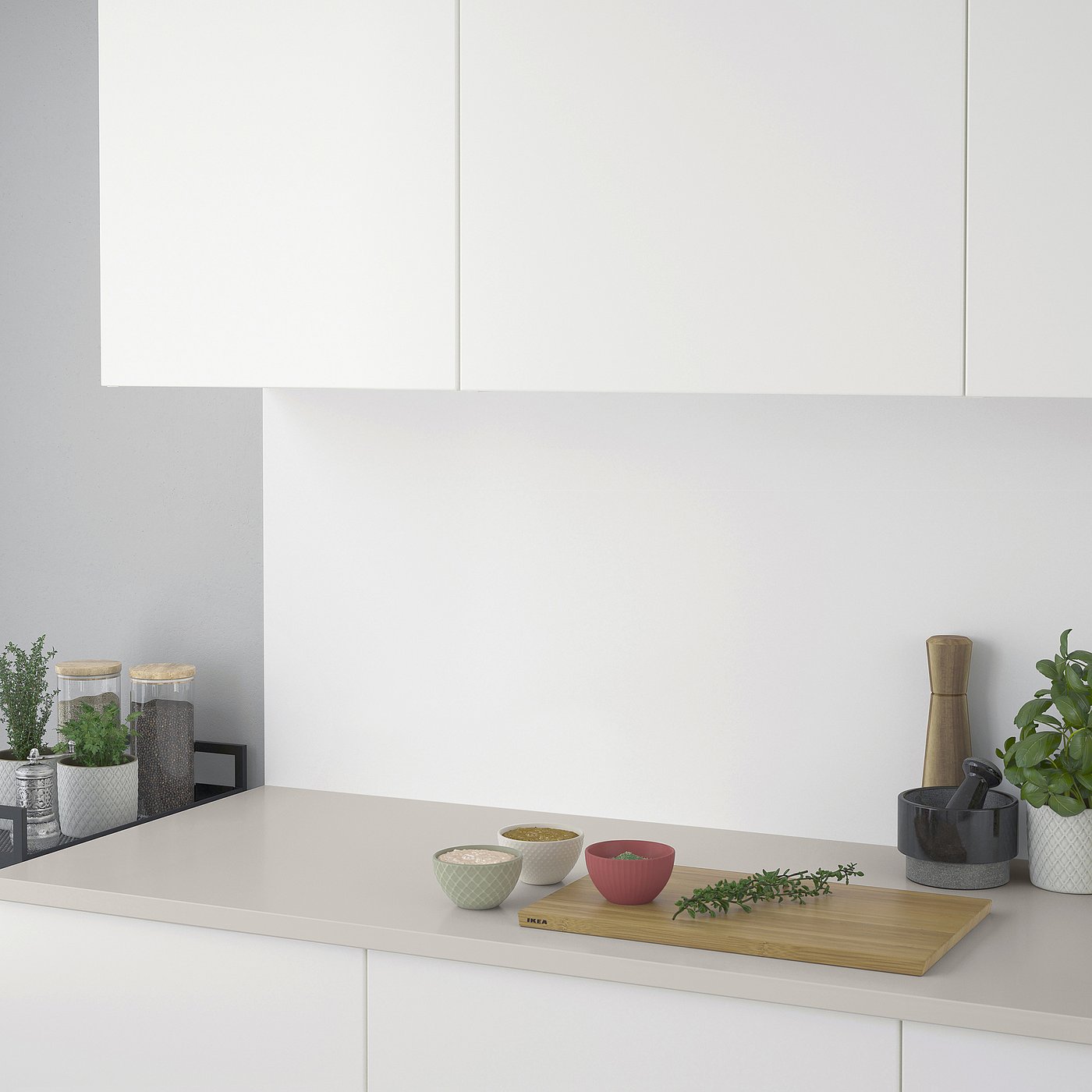 Modern kitchen countertop with seasonings: bowls, herbs, pepper grinder, and plant.