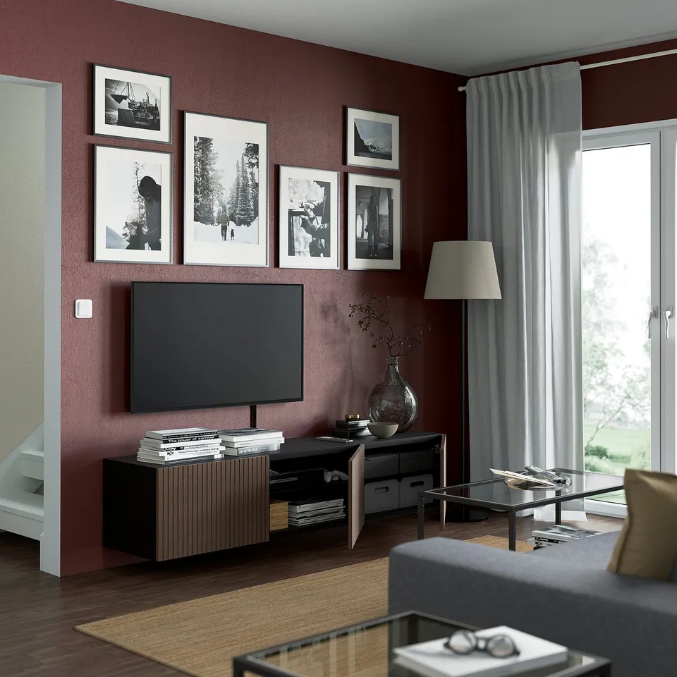 Modern maroon living room with BESTÅ tv bench, flat screen, and glass coffee table.