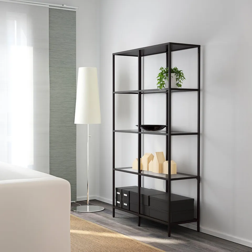 Modern bookcase with glass shelves; holds decorative items, like plants and wooden blocks.