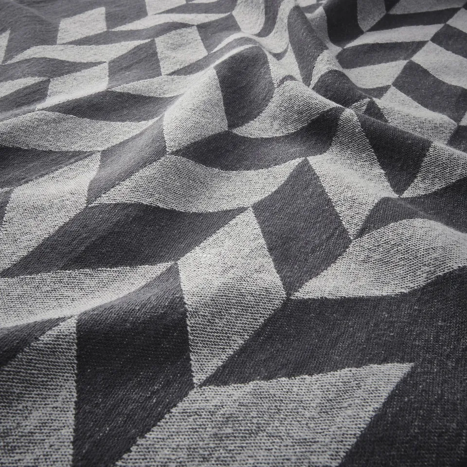 Black and white geometric textile close-up. Intricate diamond patterns, crisp texture, high-quality fabric.