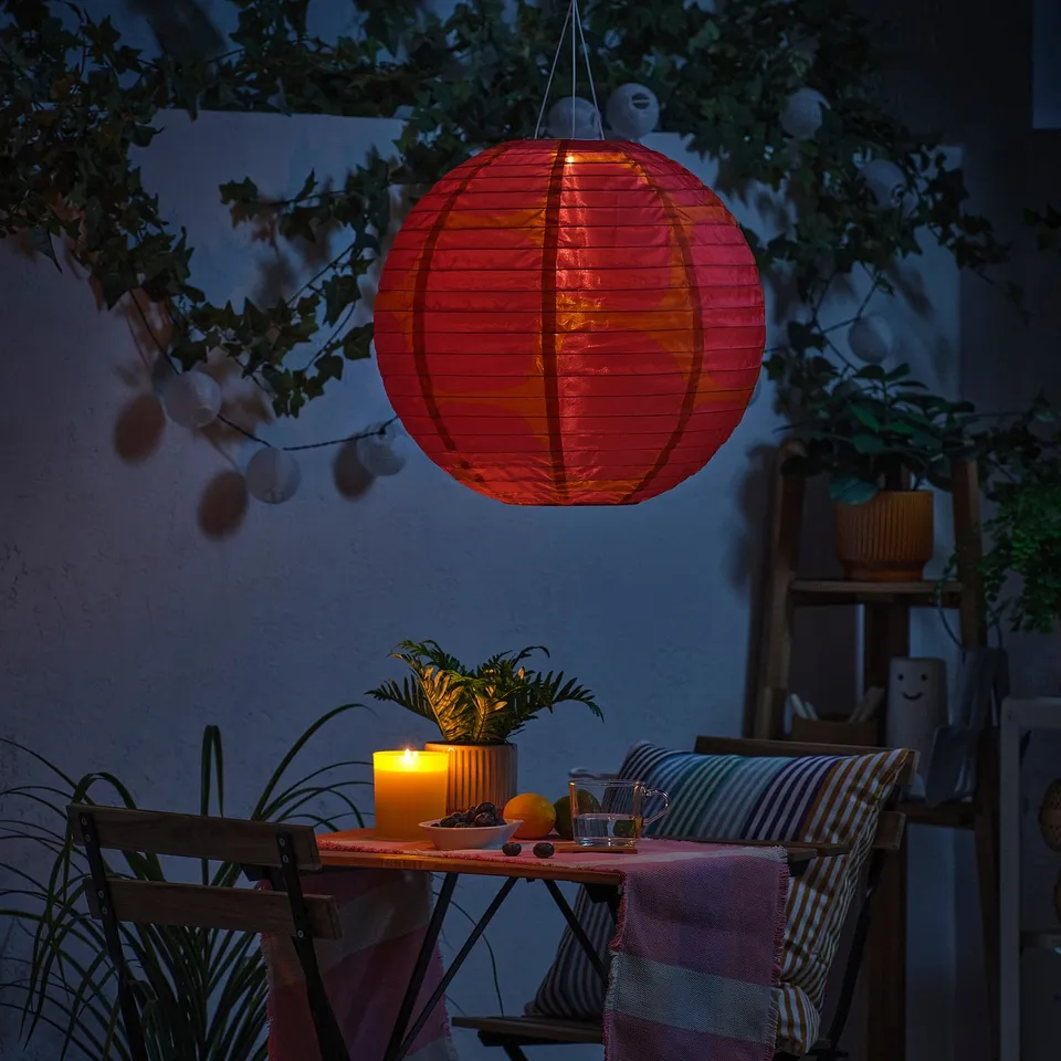 SOLVINDEN lantern lights patio with plants and candles.