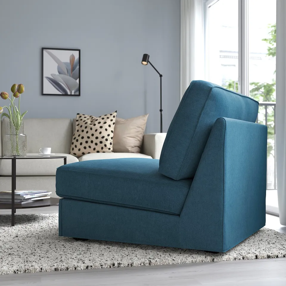 Teal KIVIK sofa-bed in living room with flowers and minimalist design.