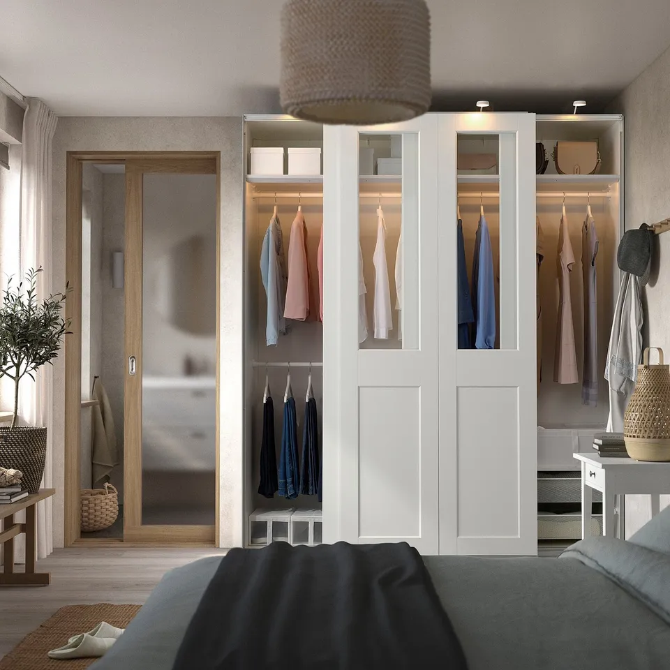 Modern bedroom with PAX wardrobe, built-in lights, grey bed, open closet, plant.