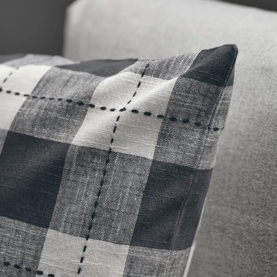 Close-up of a striped cushion cover with visible stitching, showcasing high-quality textile and design details.