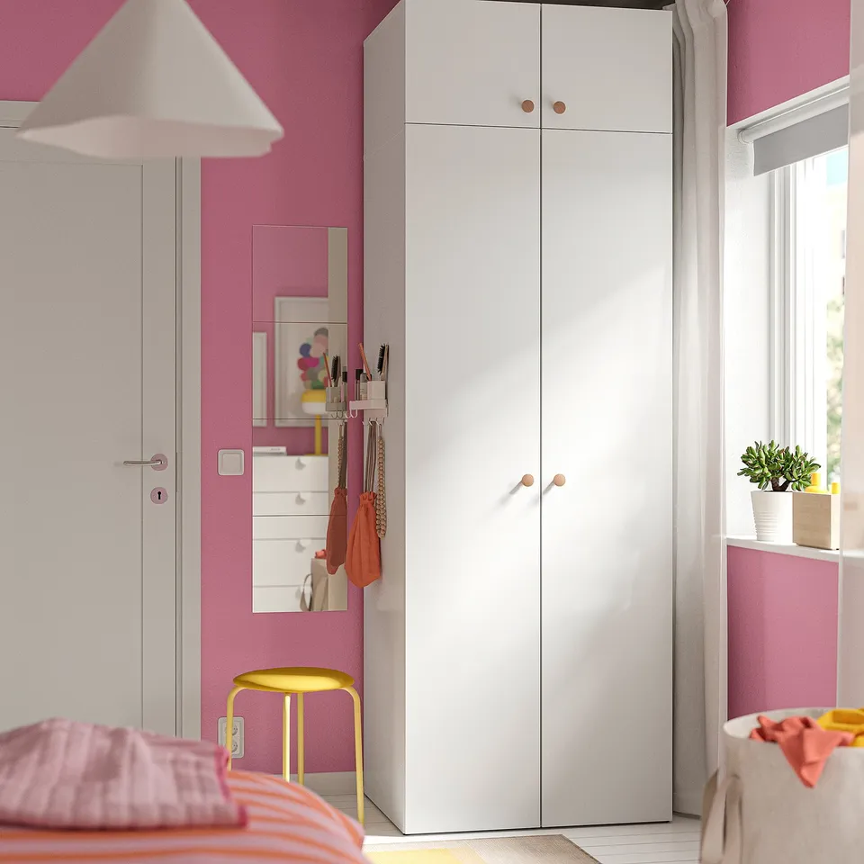 Modern pink room with white LASTARE wardrobe, tall and slim, next to a window and yellow stool.