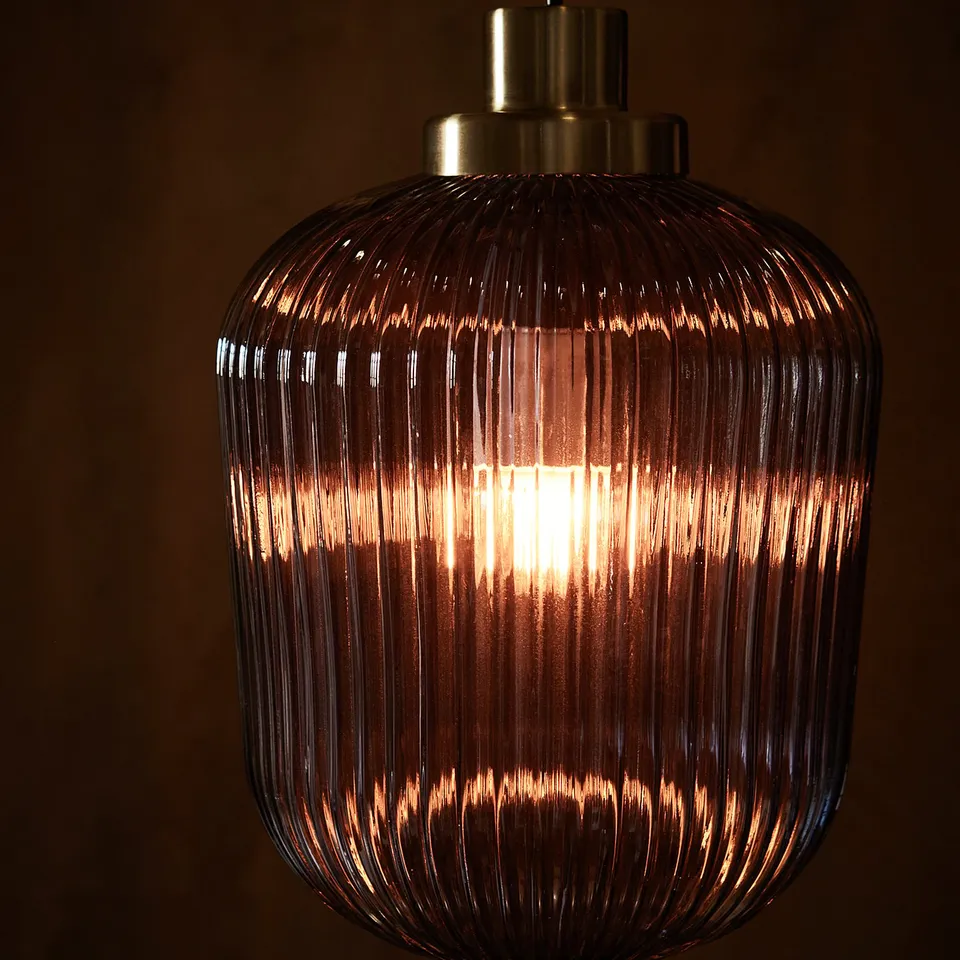 Modern pendant lamp, SOLKLINT, in bronze with ribbed glass shade, casting warm light.