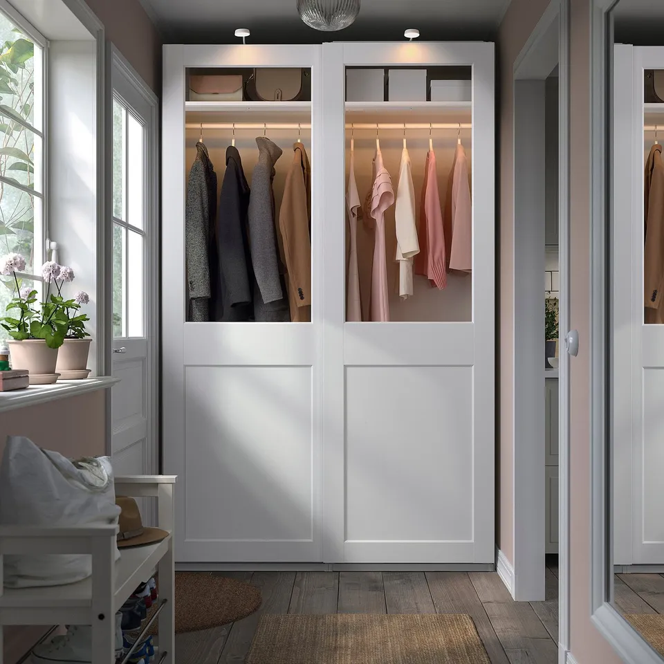 PAX wardrobe with glass doors, white panels, neat clothes.
