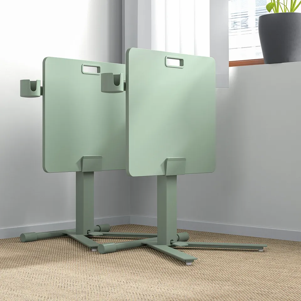 Two green height-adjustable laptop tables in a room, ideal for presentations or small workspaces.