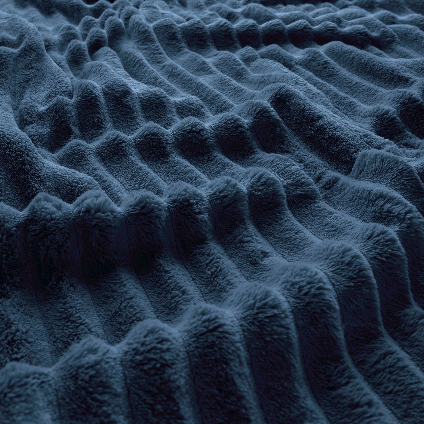 Dark blue, soft, textured fleece bedspread, showing its thick, fluffy surface.