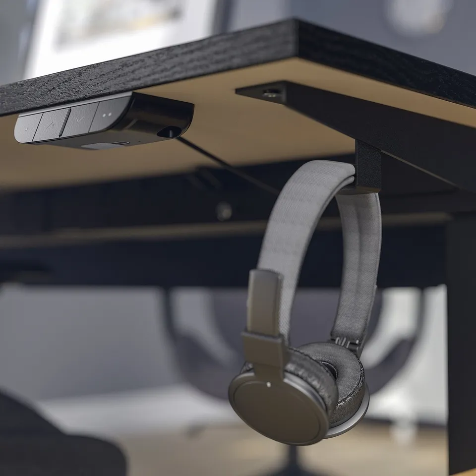 Desk with hooks, one holding headphones.