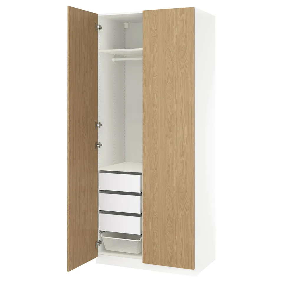 White PAX wardrobe with wooden doors, three drawers, shelf, and hanging rail.