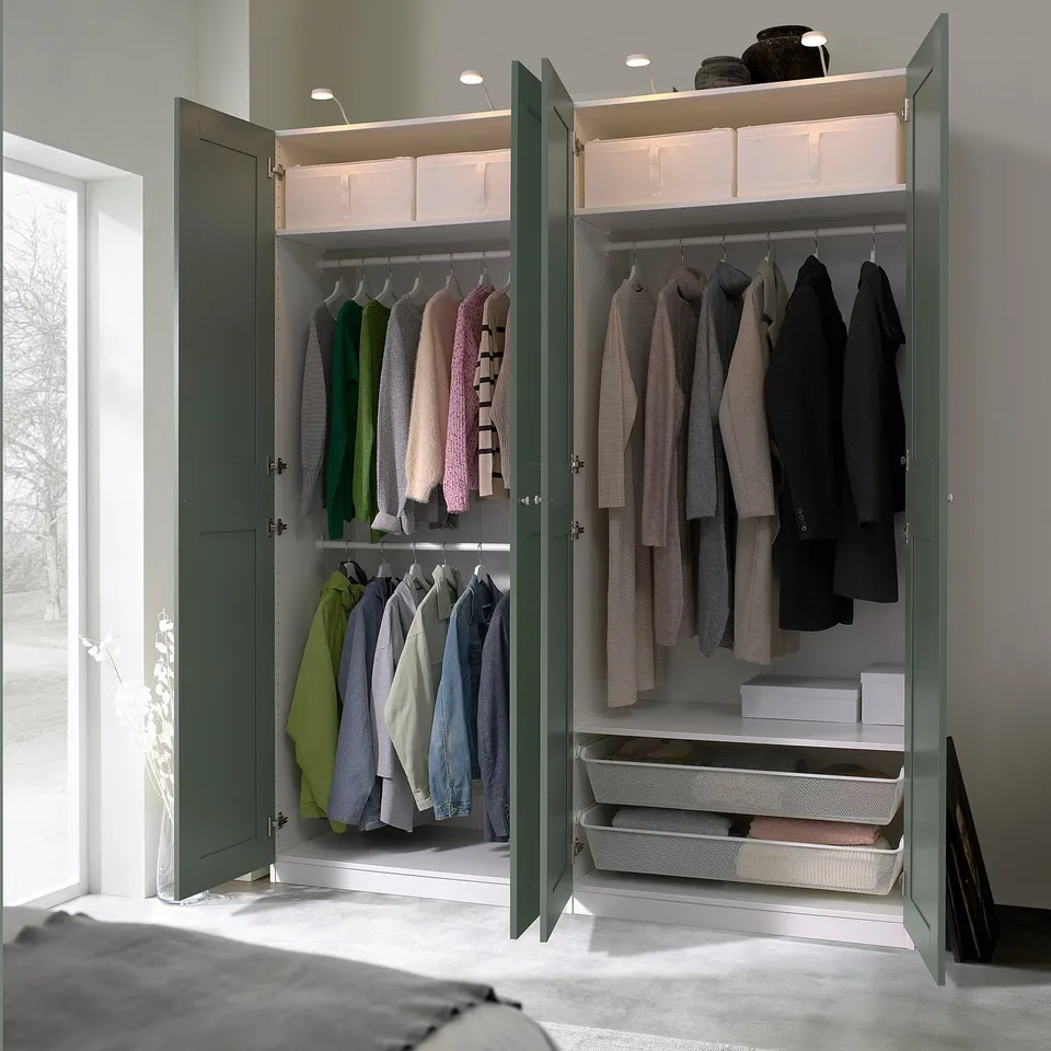 Open wardrobe with clothes hangers, shelves, and storage bins, mounted on wall.