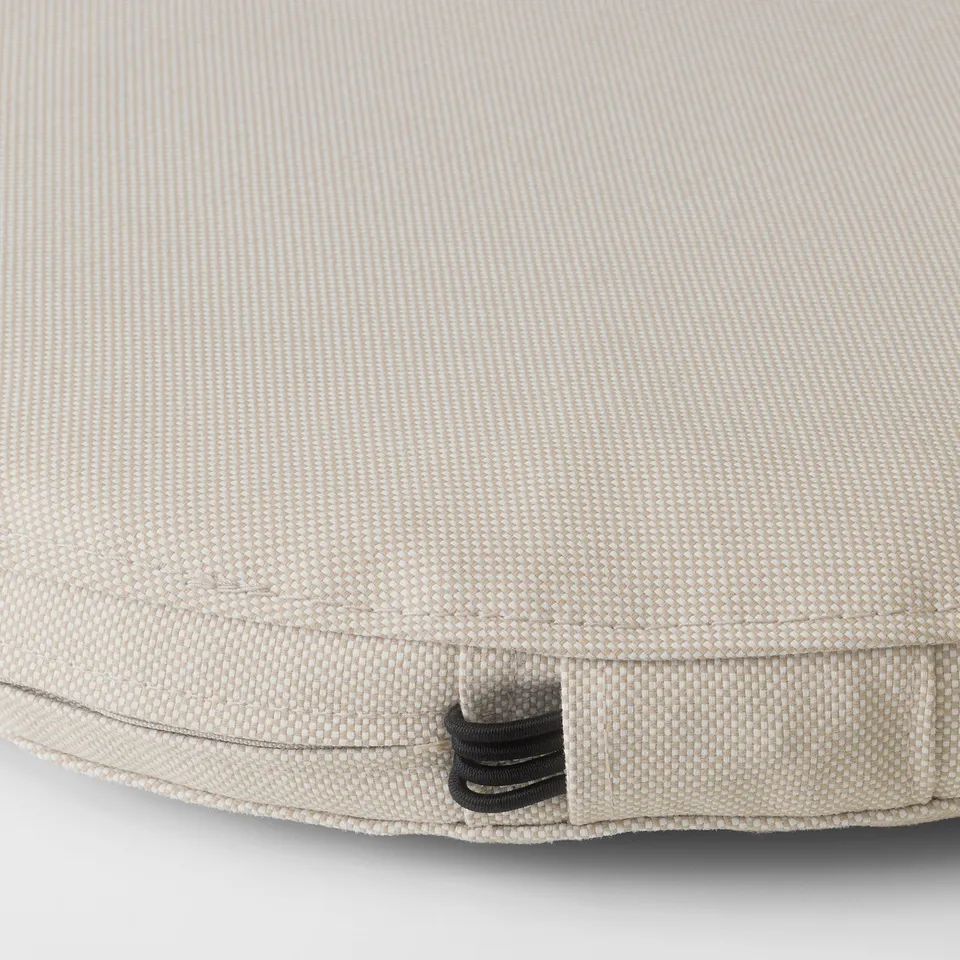 Close-up of durable, textured outdoor cushion, featuring elastic strap for secure attachment.