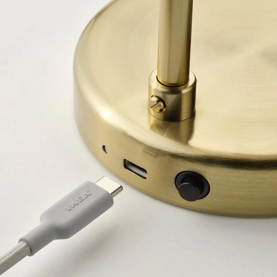 Golden lamp base with usb-c charging port and switch; ikea branded cable attached.