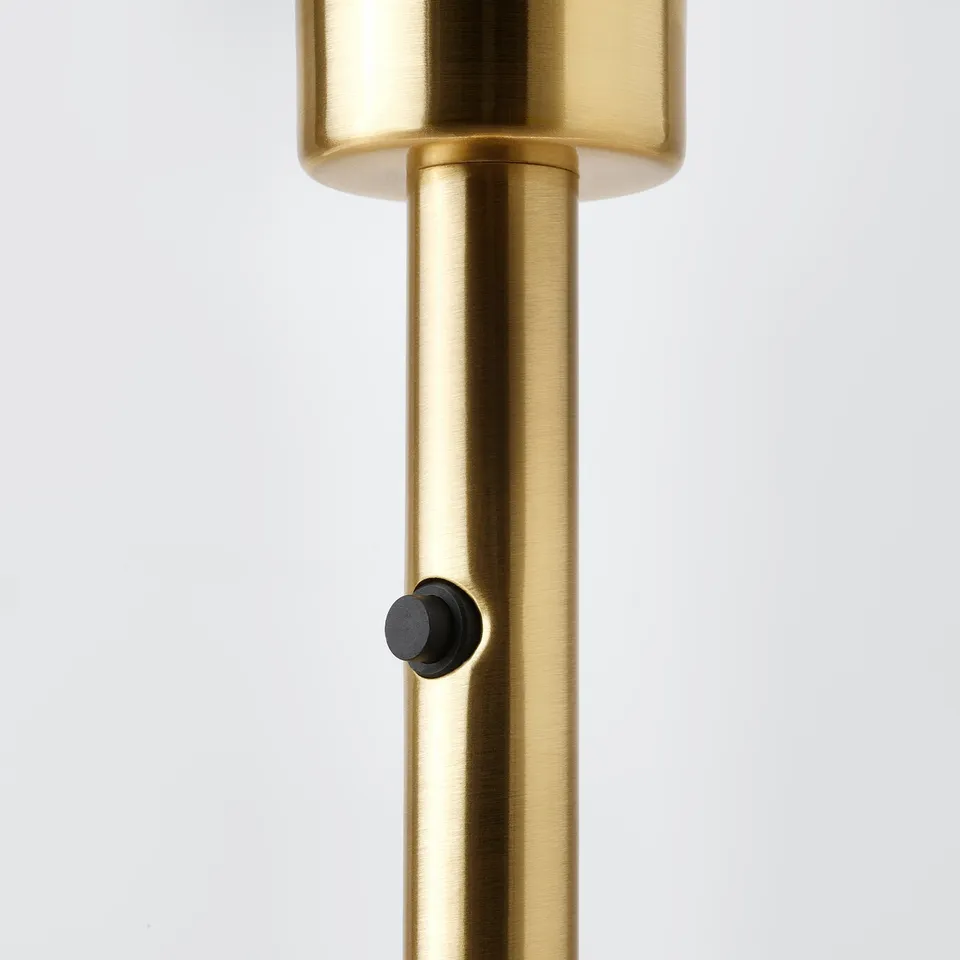 Gold-colored metal lamp base with sleek design and black toggle switch.