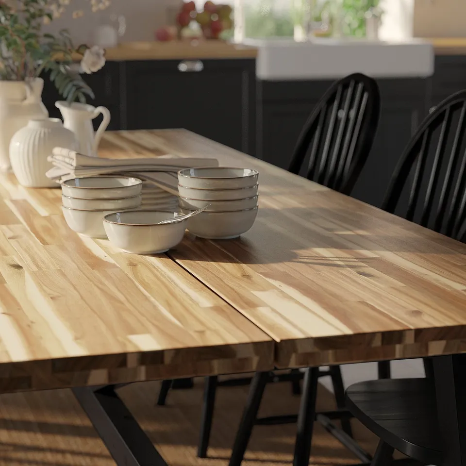 Wooden table with bowls and napkins, set near kitchen.