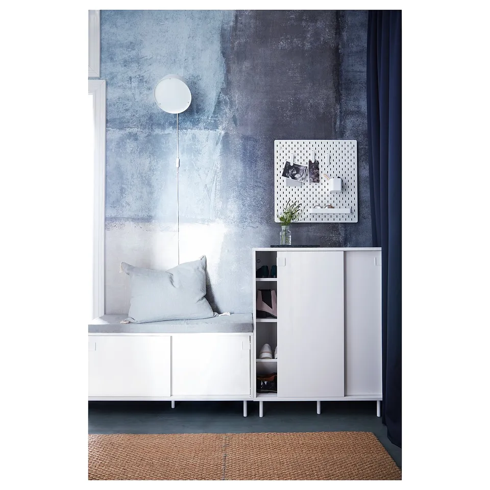 Modern white shoe cabinet with sliding doors; minimalist design.