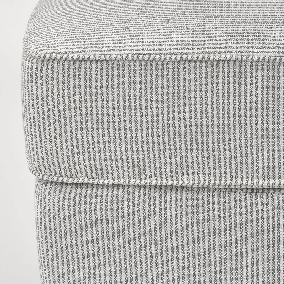 Close-up of striped, textured upholstery on a high-quality, cushioned footstool.