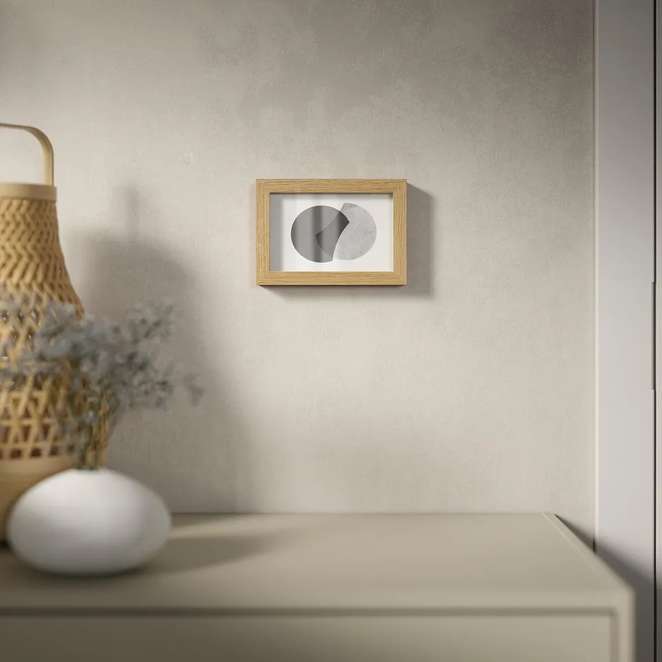 Minimalist framed art with geometric shapes hangs on wall, versatile for vertical/horizontal.