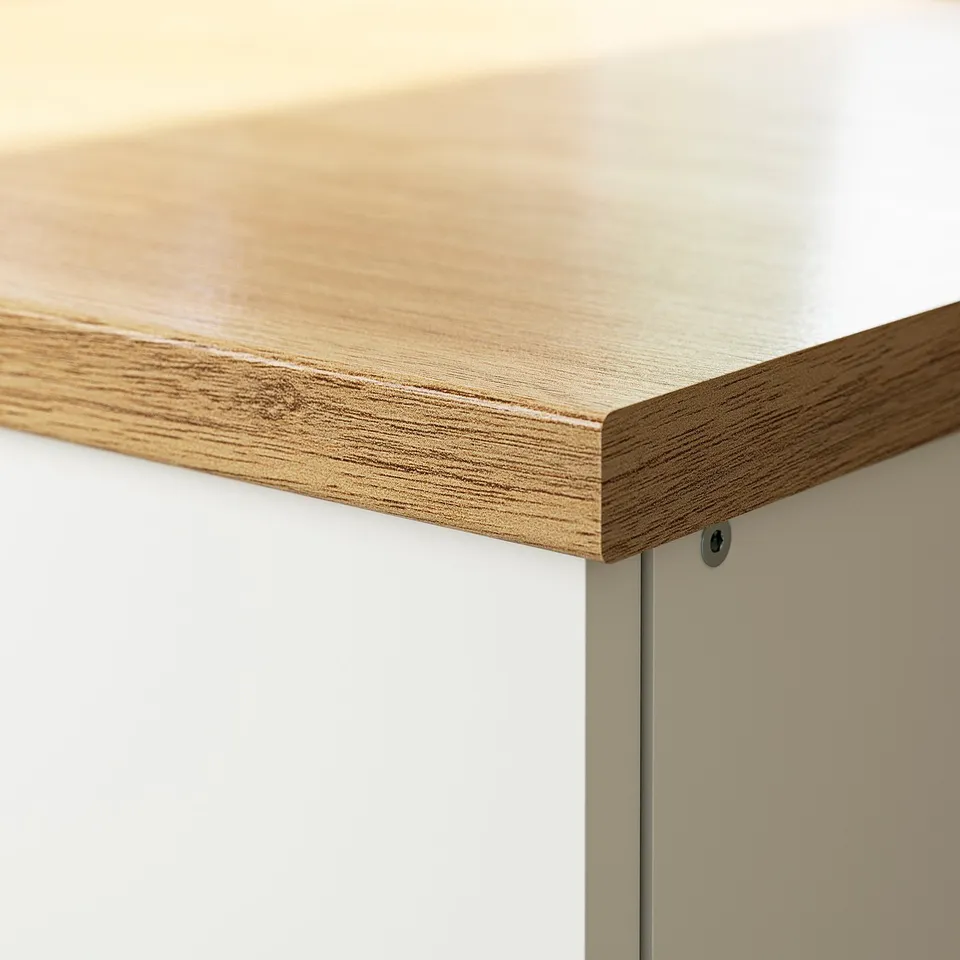Close-up of modern kitchen countertop with smooth, light wood finish, clean edges, set against a white cabinet.