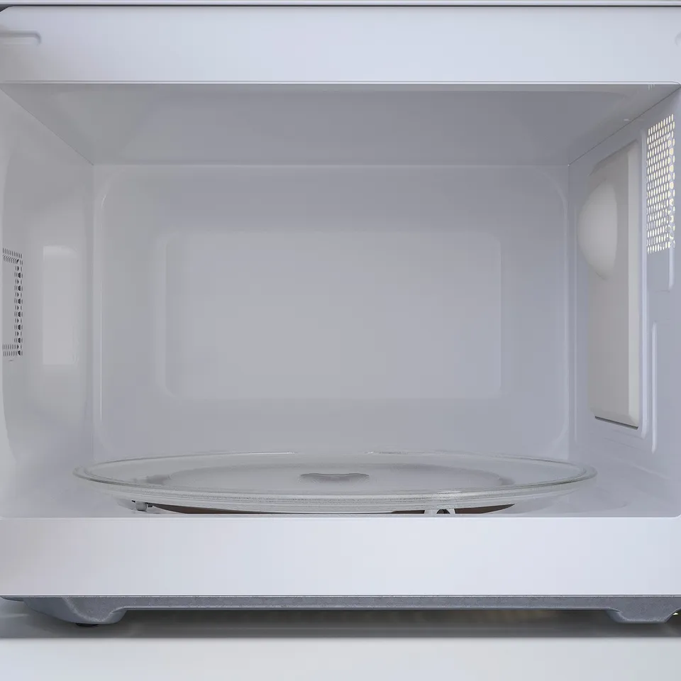 White microwave interior with turntable, no food present.