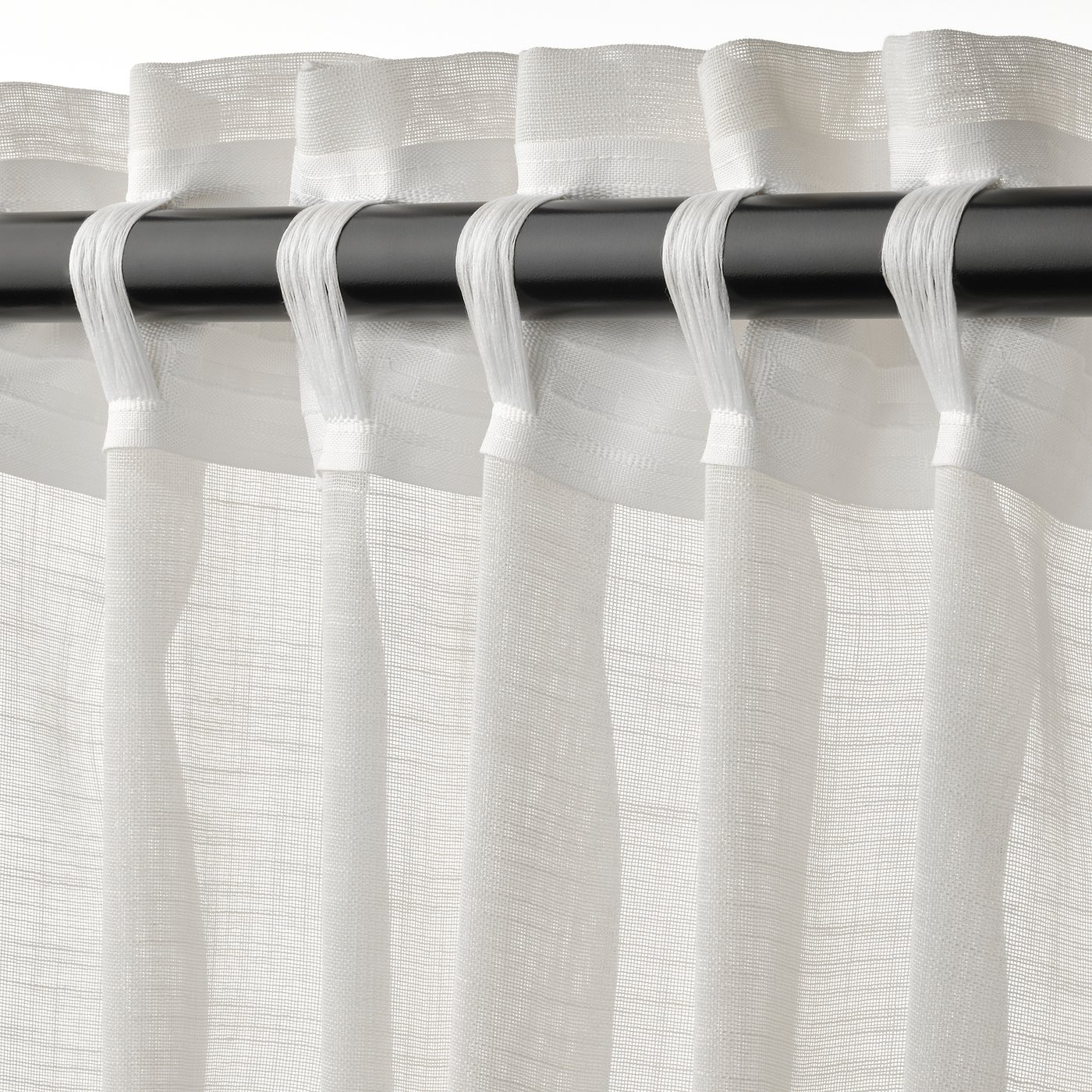 Sheer curtains with tabs philtre light, offering privacy and an airy feel.