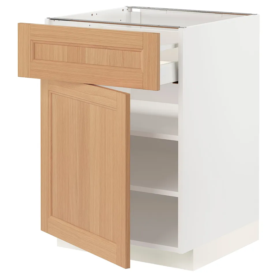 A white ikea METOD kitchen cabinet with oak drawers and door, one drawer open.