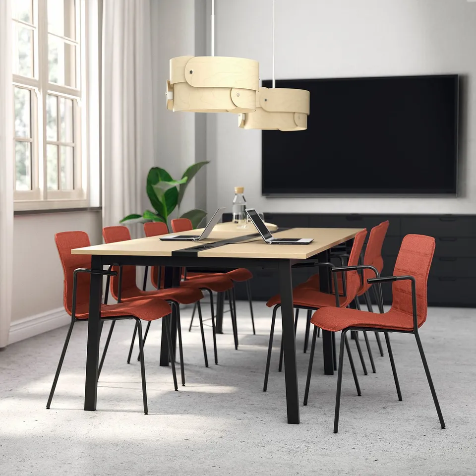 Conference table with red chairs, tv, curtains in modern room.