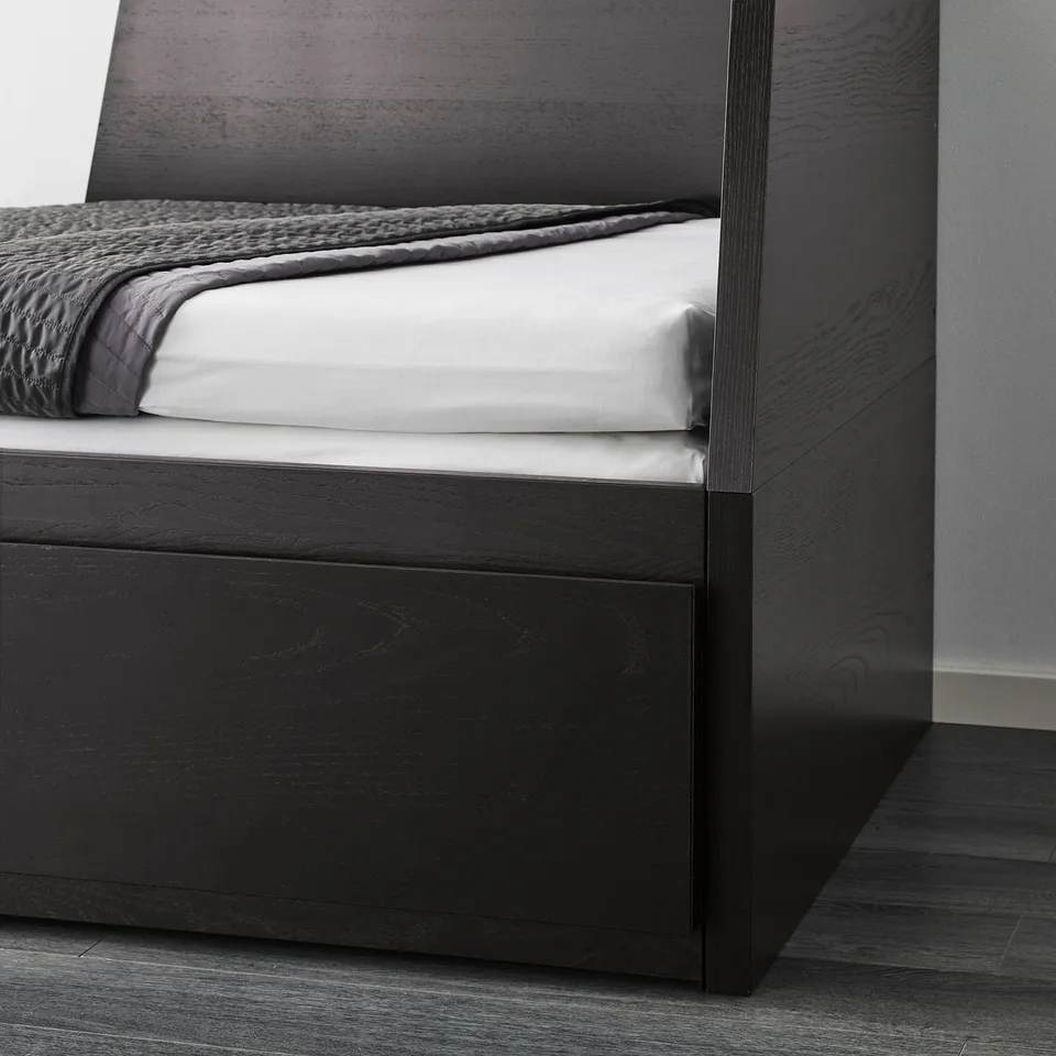 Black wooden day-bed with white mattress and grey blanket.