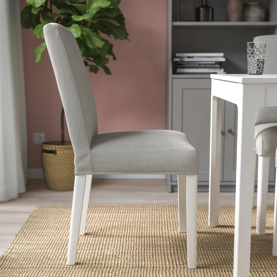 A modern dining chair with grey upholstery and white legs; part of a compact, extendable dining set.