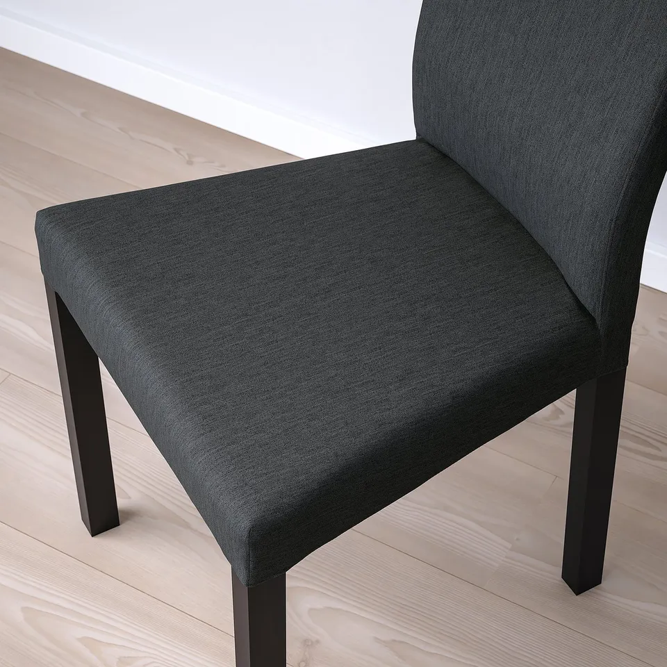 Black upholstered chair on wooden floor, showcasing quality fabric and sturdy wooden legs.